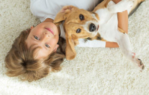 Boy on clean carpet with dog
